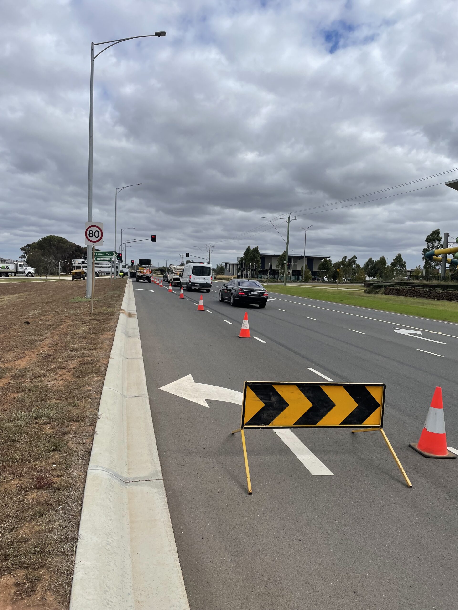 Traffic diversion setup with cones and signage on a multi-lane road during roadside work