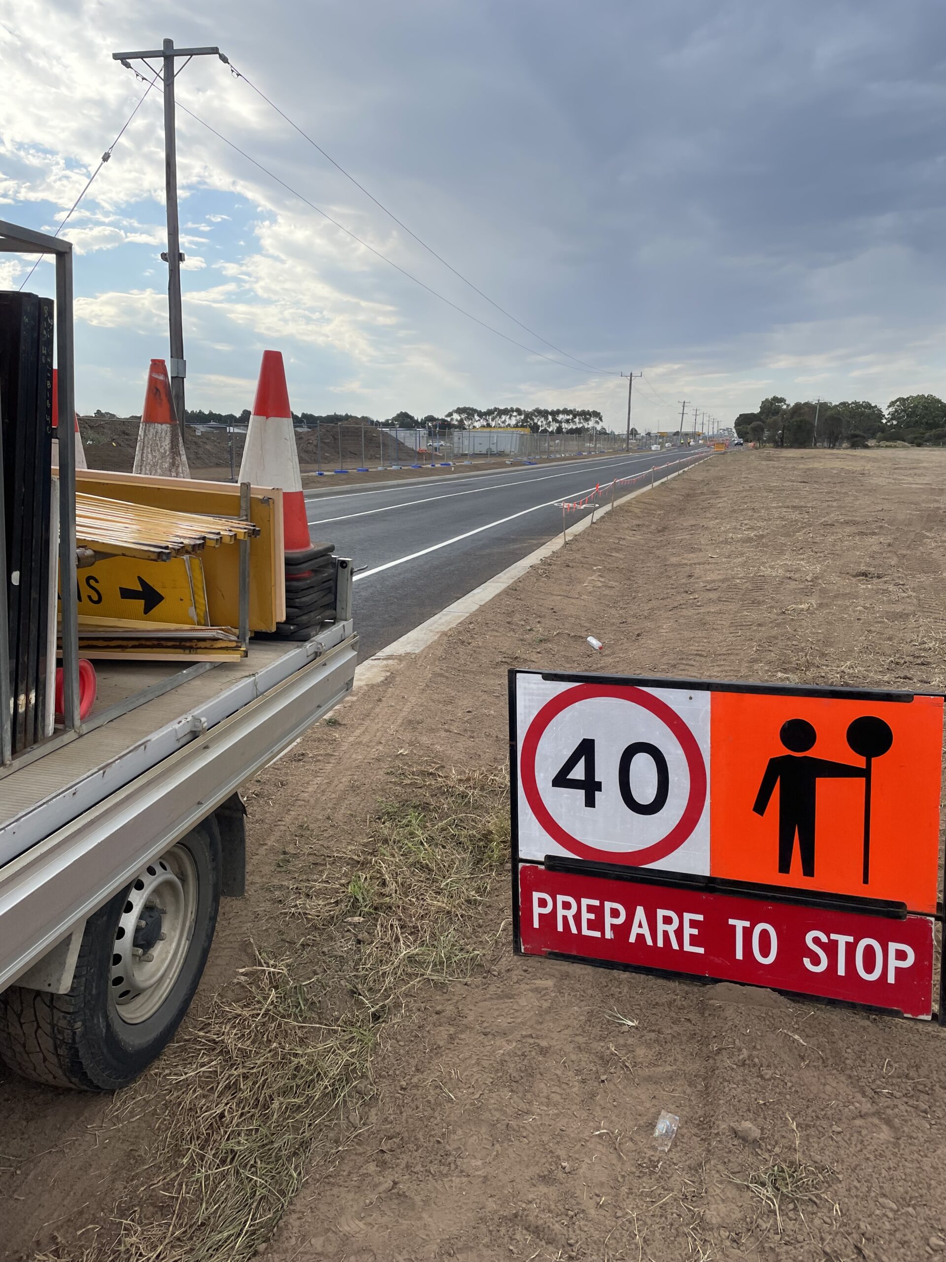 Temporary roadwork sign and traffic cones indicating reduced speed near a construction zone